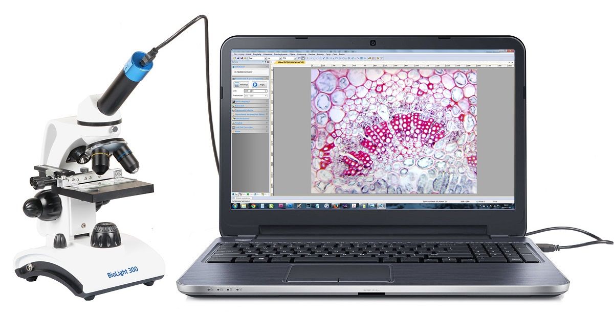 Mikroskop i laptop. Na laptopie widać powiększone próbki. Zdjęcie na białym tle. 